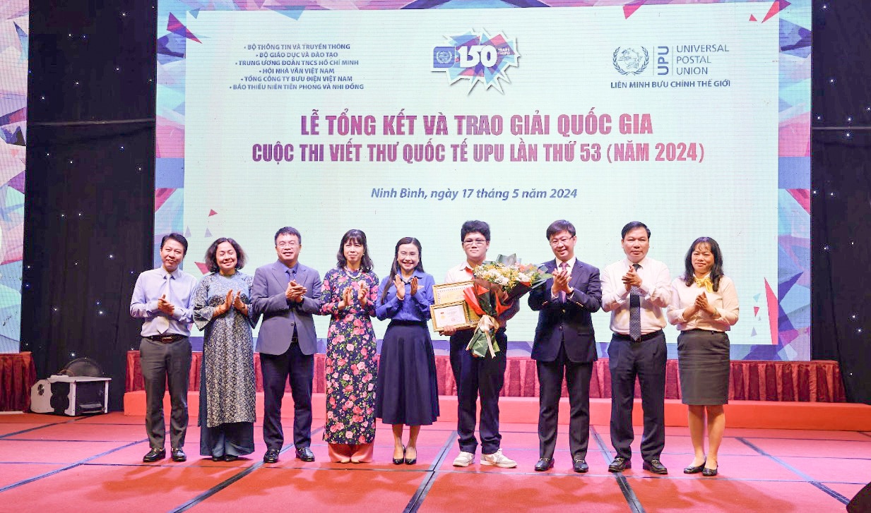 Các đại biểu trao chứng nhận giải nhất của cuộc thi viết quốc tế UPU lần thứ 53 cho em Nguyễn Đỗ Quang Minh (Đà Nẵng) - Ảnh: HÀ THƯƠNG