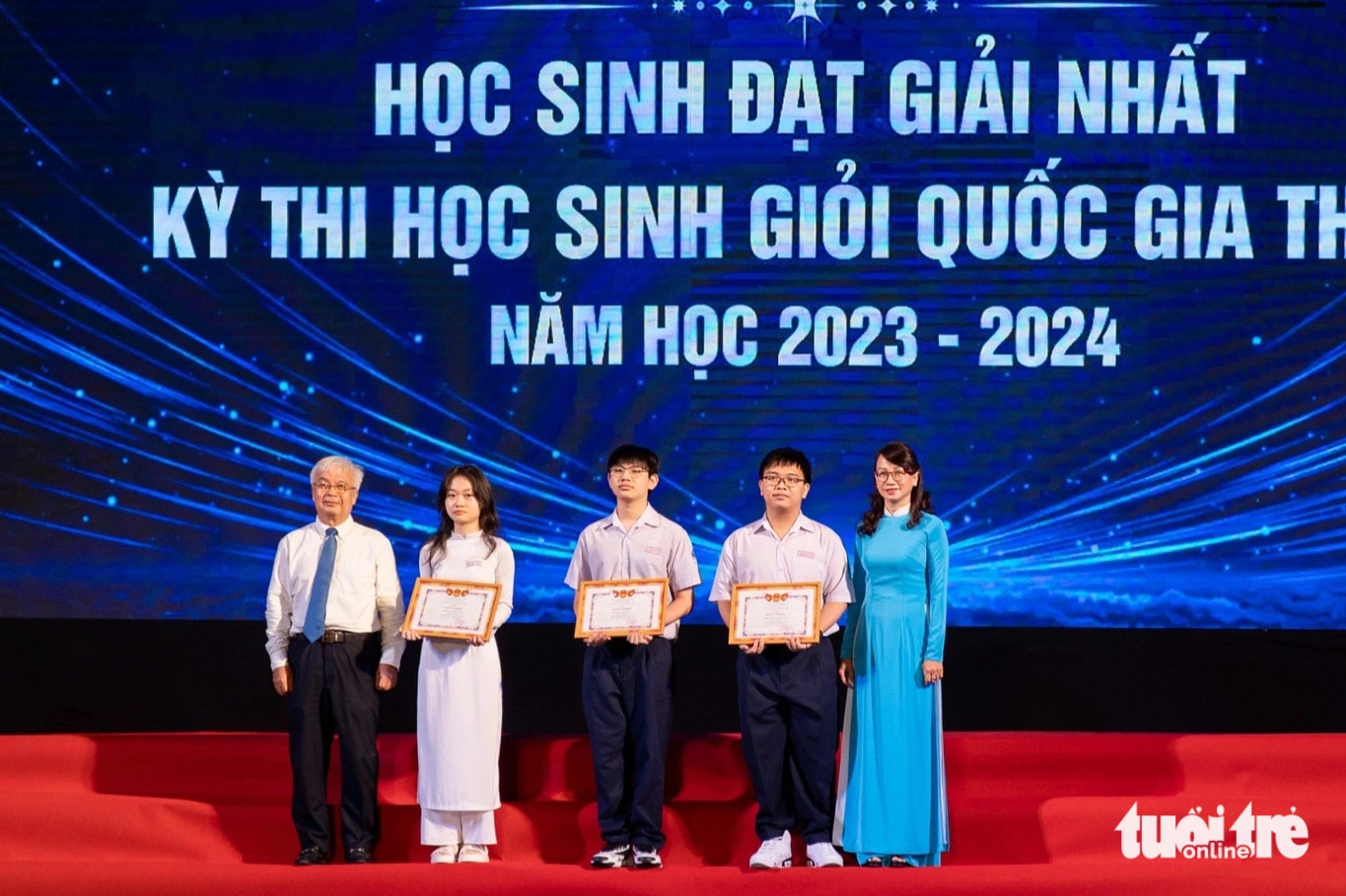 Khen thưởng 3 học sinh giải nhất kỳ thi học sinh giỏi quốc gia THPT năm nay. Trong đó bạn Nguyễn Hồng Anh, giải nhất và thủ khoa toàn quốc môn ngữ văn (thứ hai, từ trái sang) - Ảnh: CÔNG TRIỆU