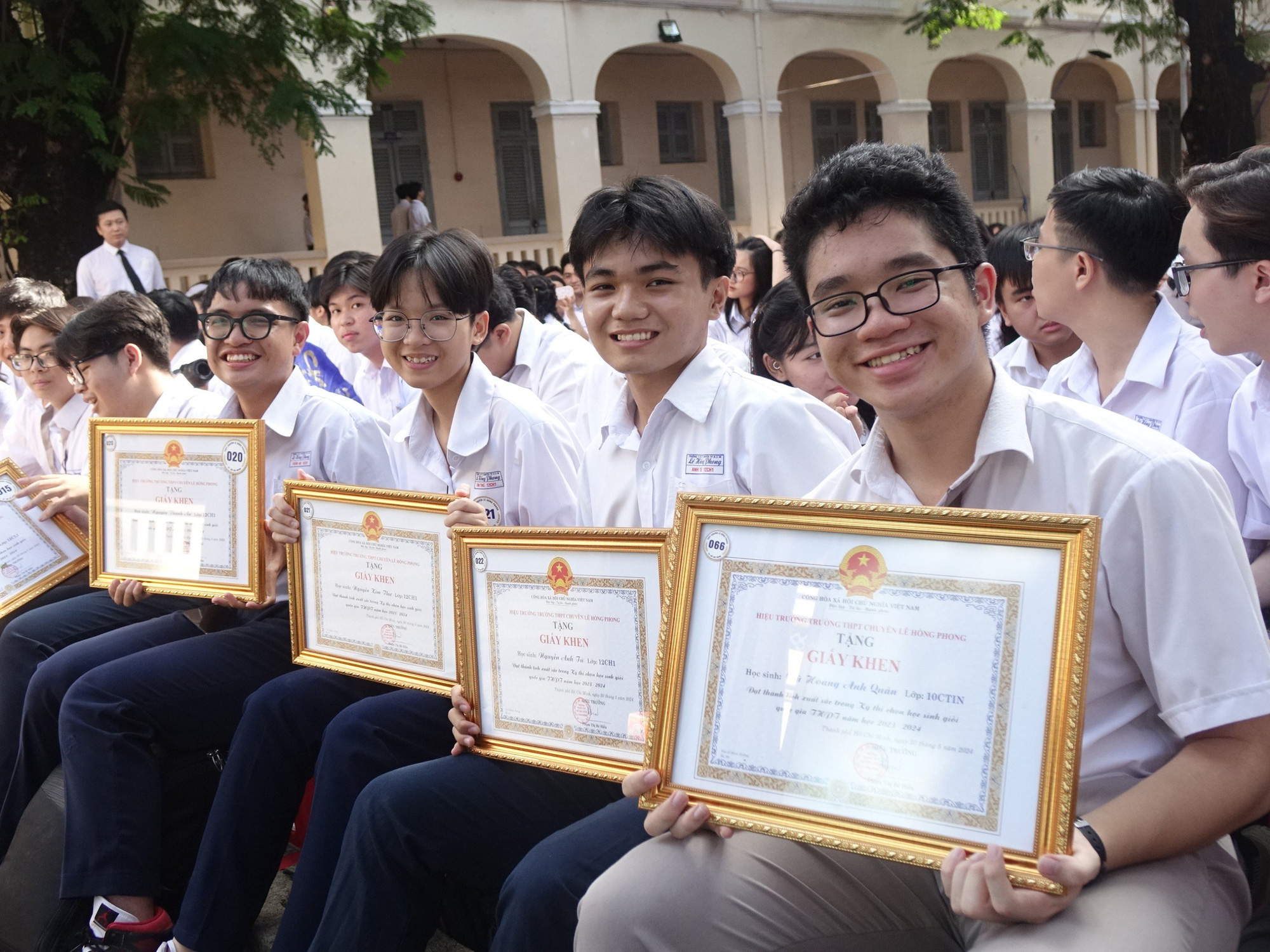 Hàng trăm học sinh trường chuyên Lê Hồng Phong nhảy flashmob xong rồi khóc trong ngày chia tay- Ảnh 4. Các em học sinh đạt giải quốc gia tươi cười rạng rỡ sau khi nhận giấy khen từ trường - Ảnh: NHƯ HÙNG