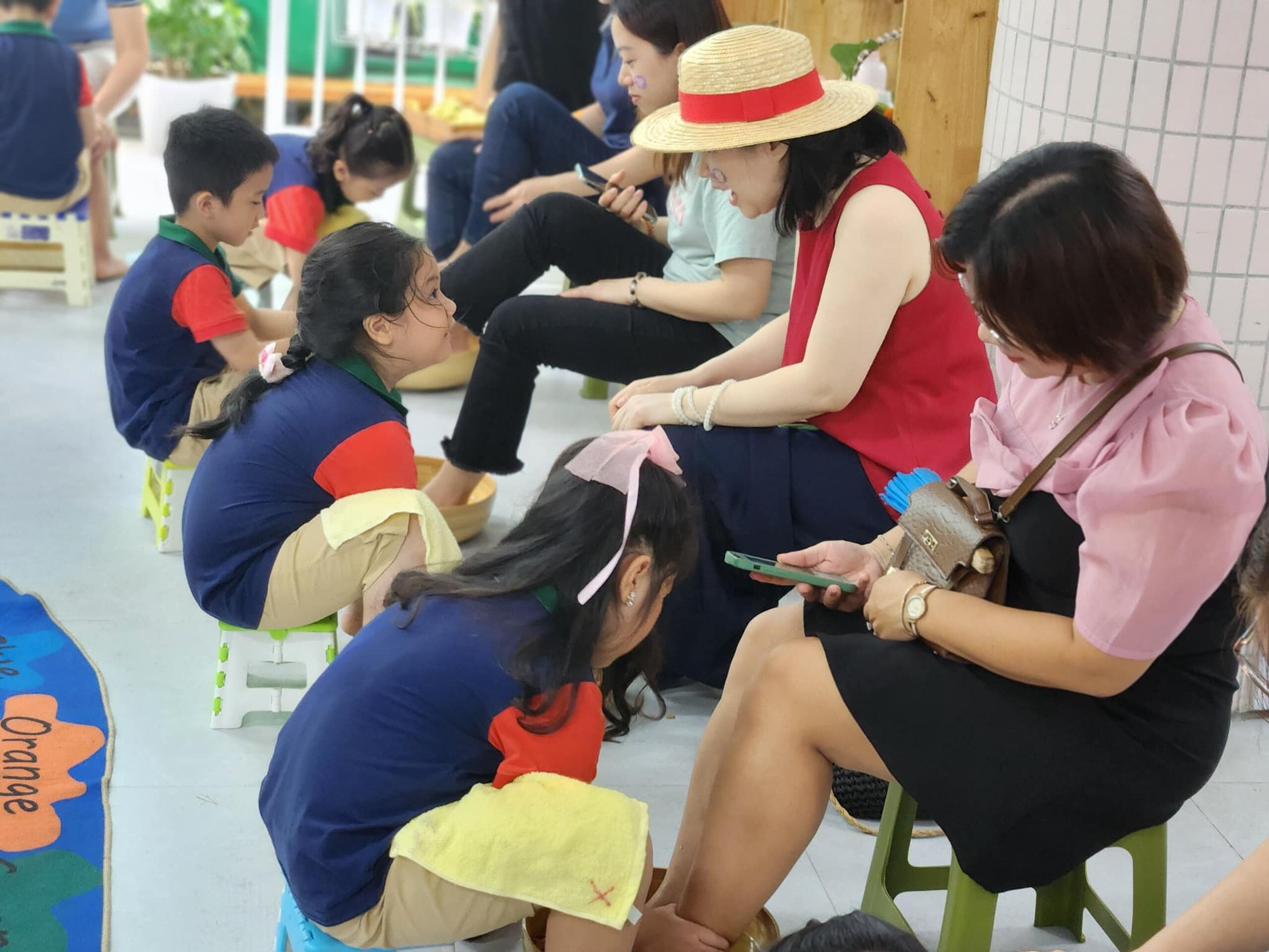 Các bé Trường mầm non Ngọc Lan (Đà Nẵng) rửa chân cho mẹ tại "lễ trưởng thành" - Ảnh: THƯ TRÂM