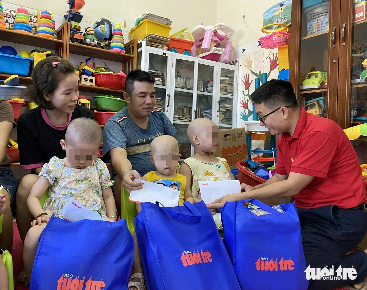 Chăm con ung thư, mẹ chỉ nguyện cầu con bớt đau- Ảnh 3. Đại diện báo Tuổi Trẻ (phải) trao quà cho bệnh nhi tại Bệnh viện Phụ sản - Nhi Đà Nẵng - Ảnh: TRƯỜNG TRUNG