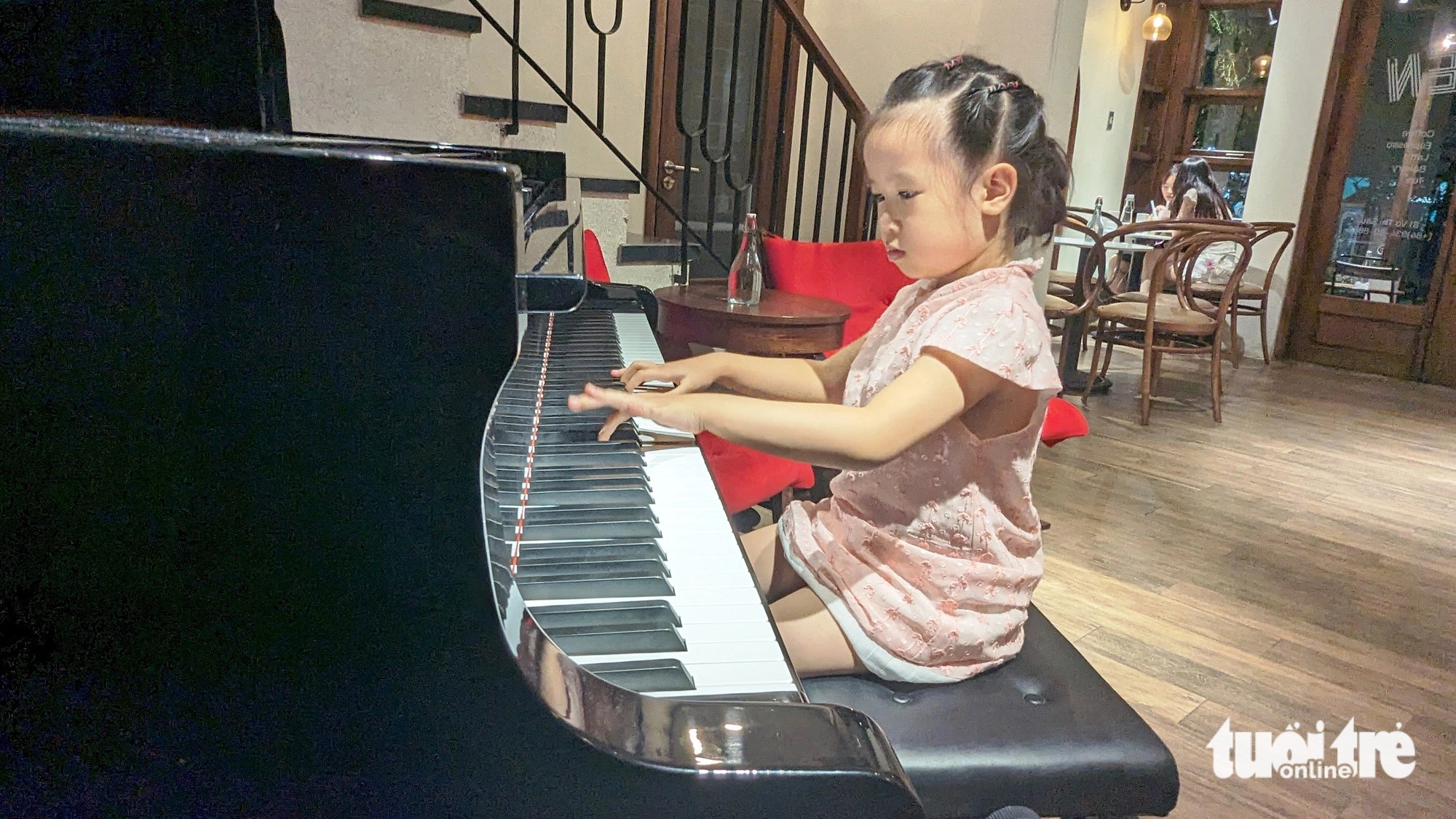 Bé Thái Tuệ Nghi (5 tuổi) biểu diễn piano ngẫu hứng tại một quán cà phê ở TP Huế - Ảnh: NHẬT LINH