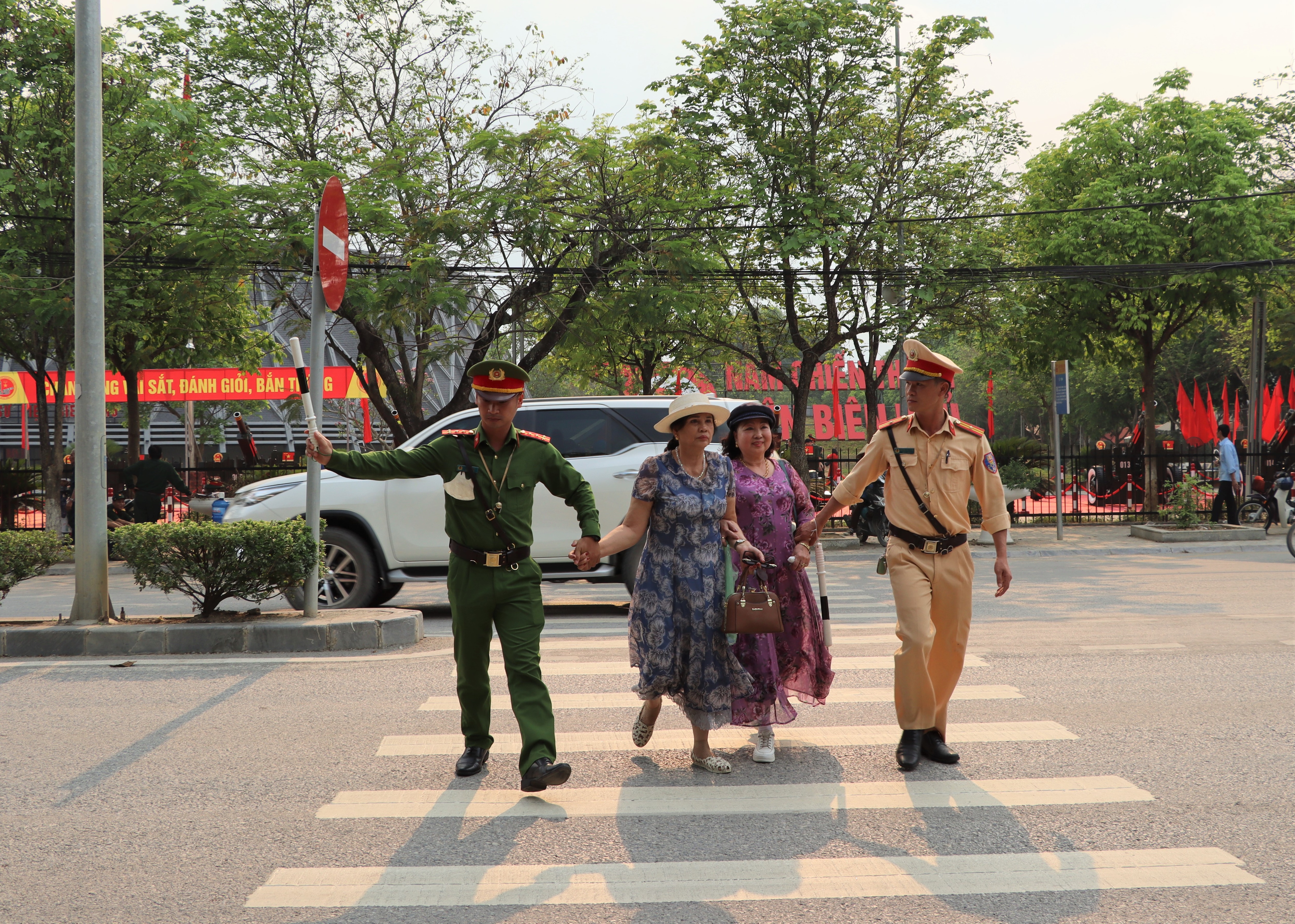Cán bộ Công an TP. Điện Biên Phủ dắt tay đưa du khách sang đường an toàn