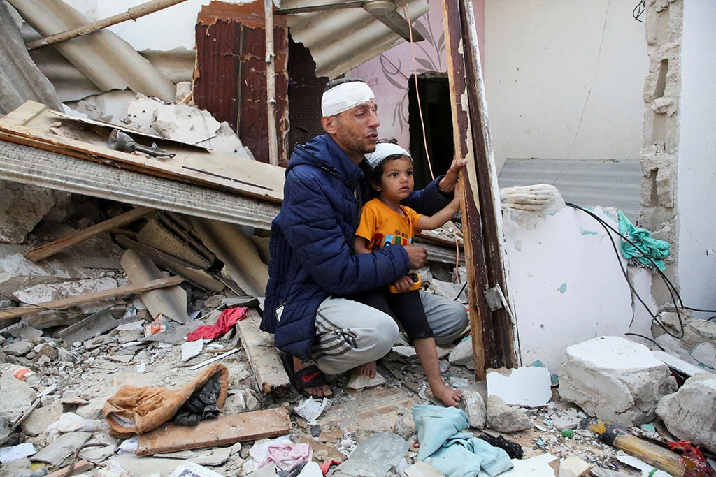 Hai cha con người Palestine tại một căn nhà đổ nát ở TP.Rafah (Dải Gaza) ngày 1.5