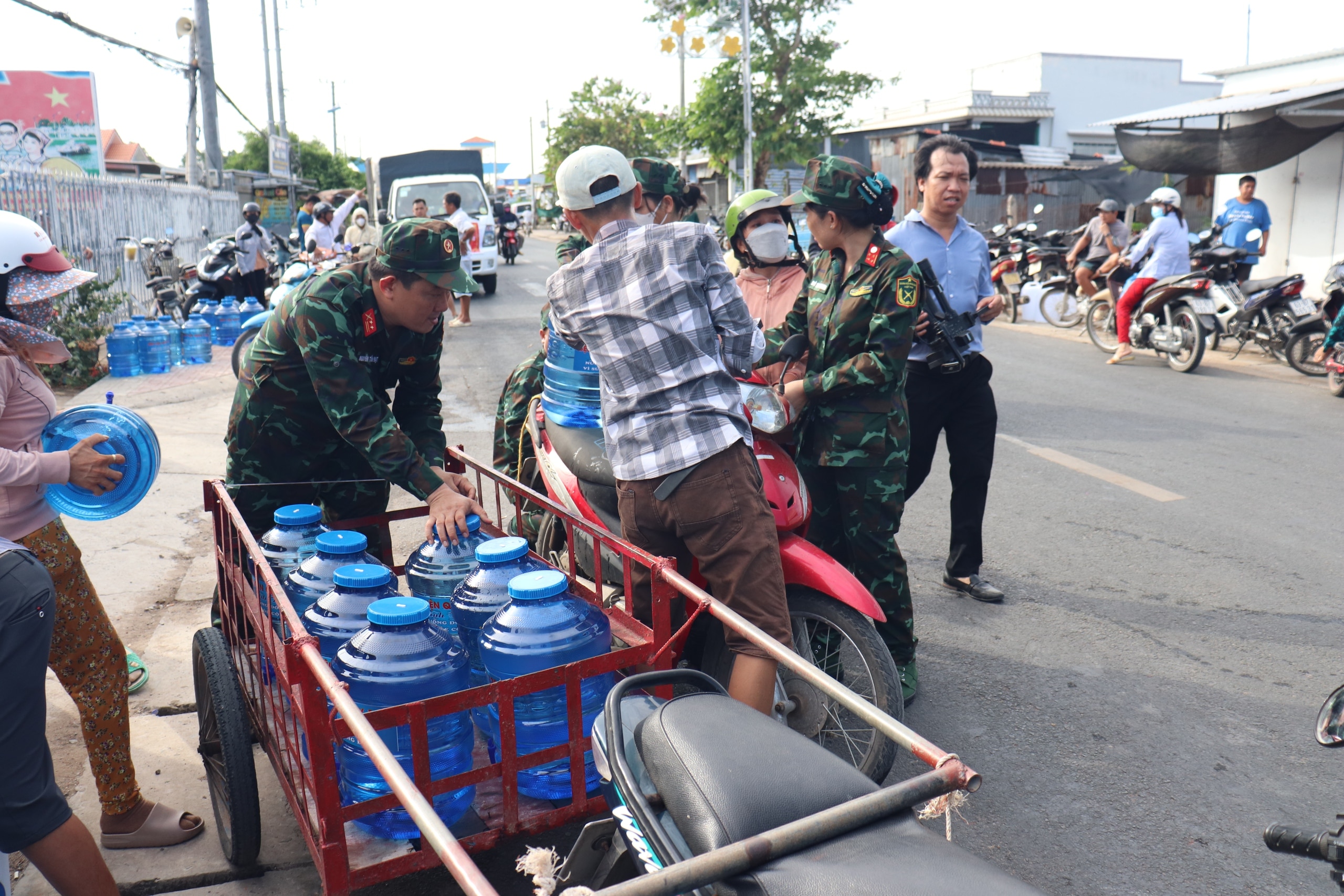 Nhân viên bệnh viện hỗ trợ người dân mang nước về nhà