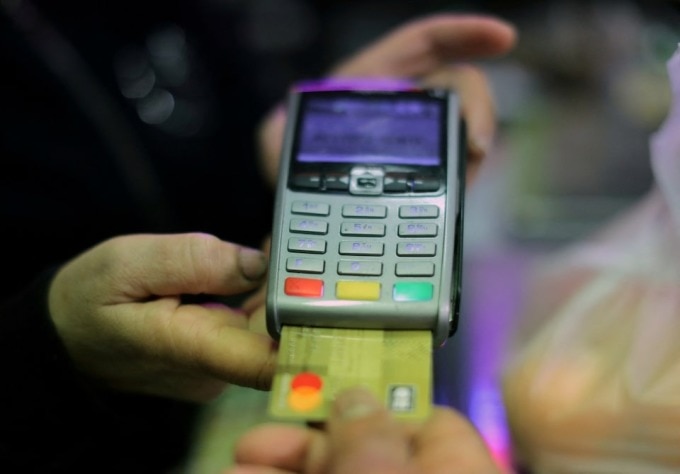 Người mua hàng đang thanh toán bằng thẻ tín dụng tại một siêu thị. Ảnh: Reuters