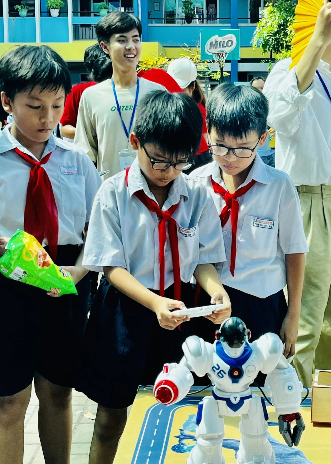 Học sinh hào hứng trải nghiệm làm 'công dân số'- Ảnh 2. Các em học sinh tiểu học chăm chú điều khiển robot tại ngày hội "Em là công dân số" - Ảnh: MỸ DUNG