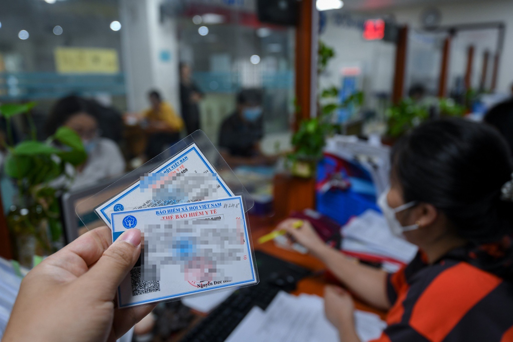 Người dân làm thủ tục bảo hiểm y tế tại Bảo hiểm xã hội quận Ba Đình, Hà Nội - Ảnh: NAM TRẦN