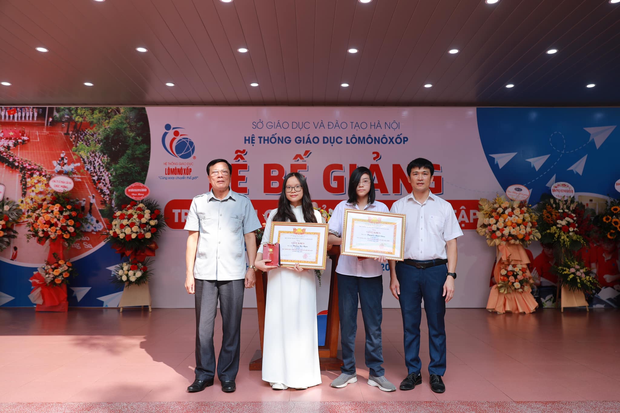 Một trường học ở Hà Nội thưởng vàng cho học sinh tiêu biểu
- Ảnh 1. Hai học sinh tiêu biểu của Trường THCS-THPT M.V. Lômônôxốp (Hà Nội) được tặng thưởng vàng trong lễ bế giảng năm học