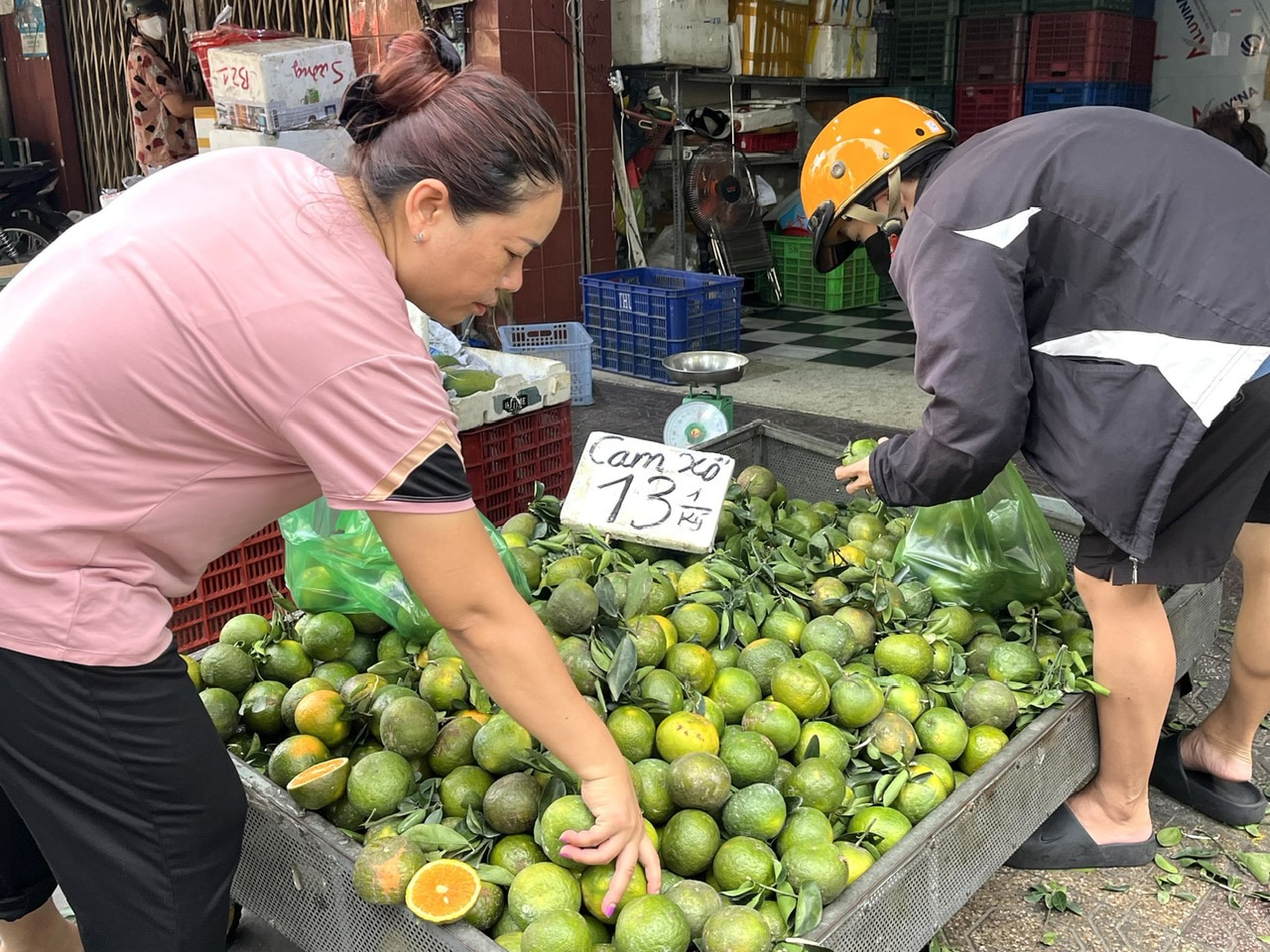 Người dân mua cam tại chợ Bà Chiểu, quận Bình Thạnh, TP.HCM - Ảnh: THÙY DƯƠNG