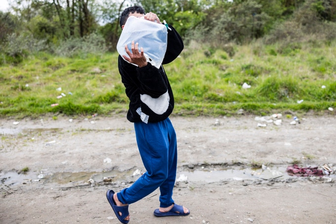 Một người Việt Nam chuyển nước tại trại di cư ở Loon-Plage, miền bắc Pháp, ngày 25/4. Ảnh: AFP