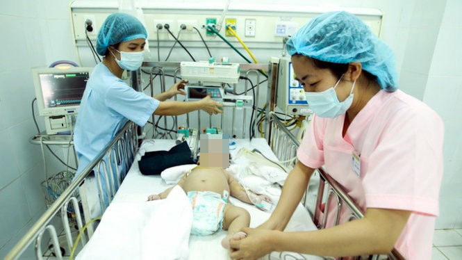 Nhân viên y tế chăm sóc một trẻ nhỏ mắc bệnh sởi - Ảnh: NGUYỄN KHÁNH 