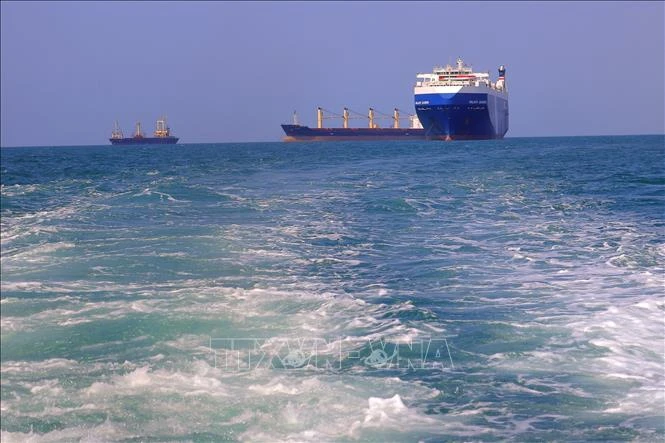Tàu chở hàng (phải) bị lực lượng Houthi bắt giữ trên đường về cảng tỉnh Hodeida (Yemen) ngoài khơi Biển Đỏ, ngày 22-11-2023. Ảnh: AFP/TTXVN