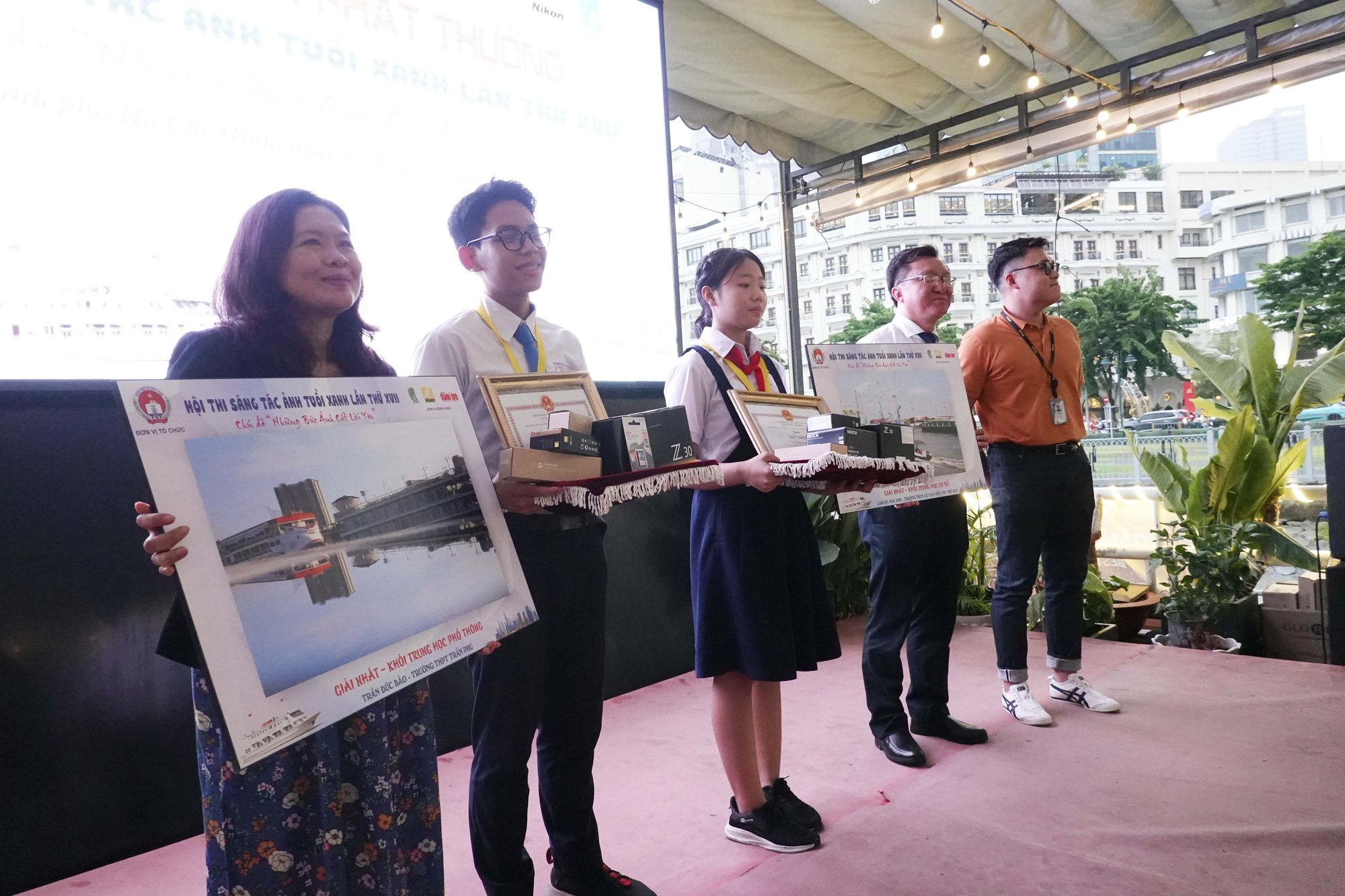 Trao giải hội thi sáng tác ảnh Tuổi Xanh 2024- Ảnh 1. Phó giám đốc Sở GD-ĐT Nguyễn Bảo Quốc và Phó tổng thư ký tòa soạn báo Tuổi Trẻ Trương Bảo Châu trao giải nhất cho 2 thí sinh bảng THCS và THPT (ở giữa) - Ảnh: NGUYỄN CÔNG THÀNH