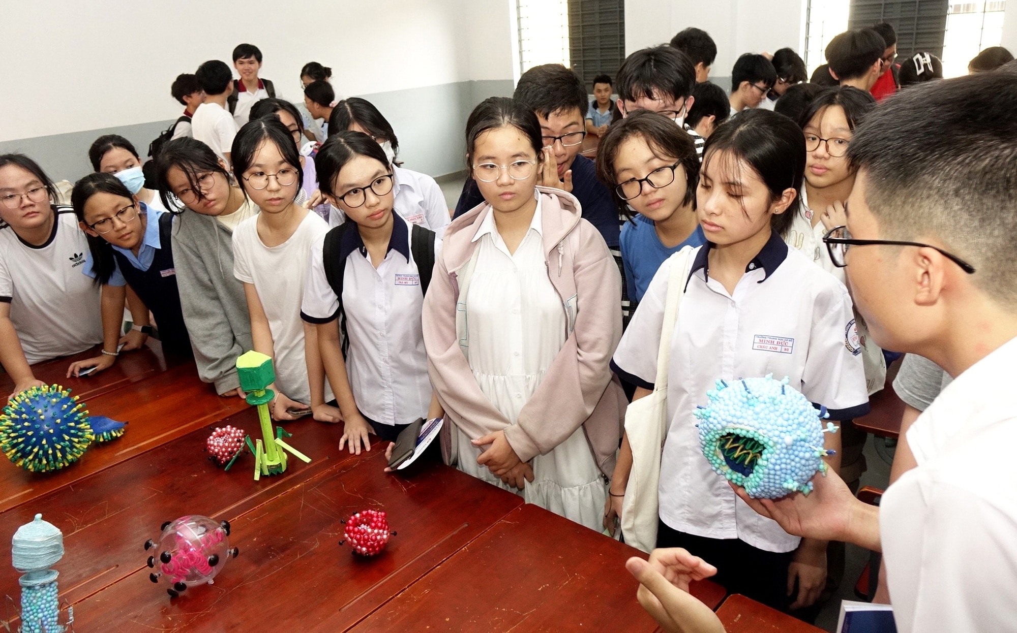 Học sinh các trường THCS ở TP.HCM lắng nghe các anh chị học sinh Trường THPT chuyên Lê Hồng Phong giới thiệu bài thực hành môn sinh học tại ngày hội tư vấn tuyển sinh vào lớp 10 chuyên vào sáng 5-5 - Ảnh: NHƯ HÙNG
