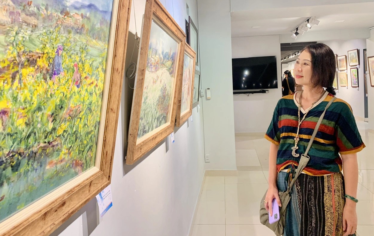 Họa sĩ Việt Kim Quyên ngắm tranh của mình tại triển lãm - Ảnh: HOÀI PHƯƠNG