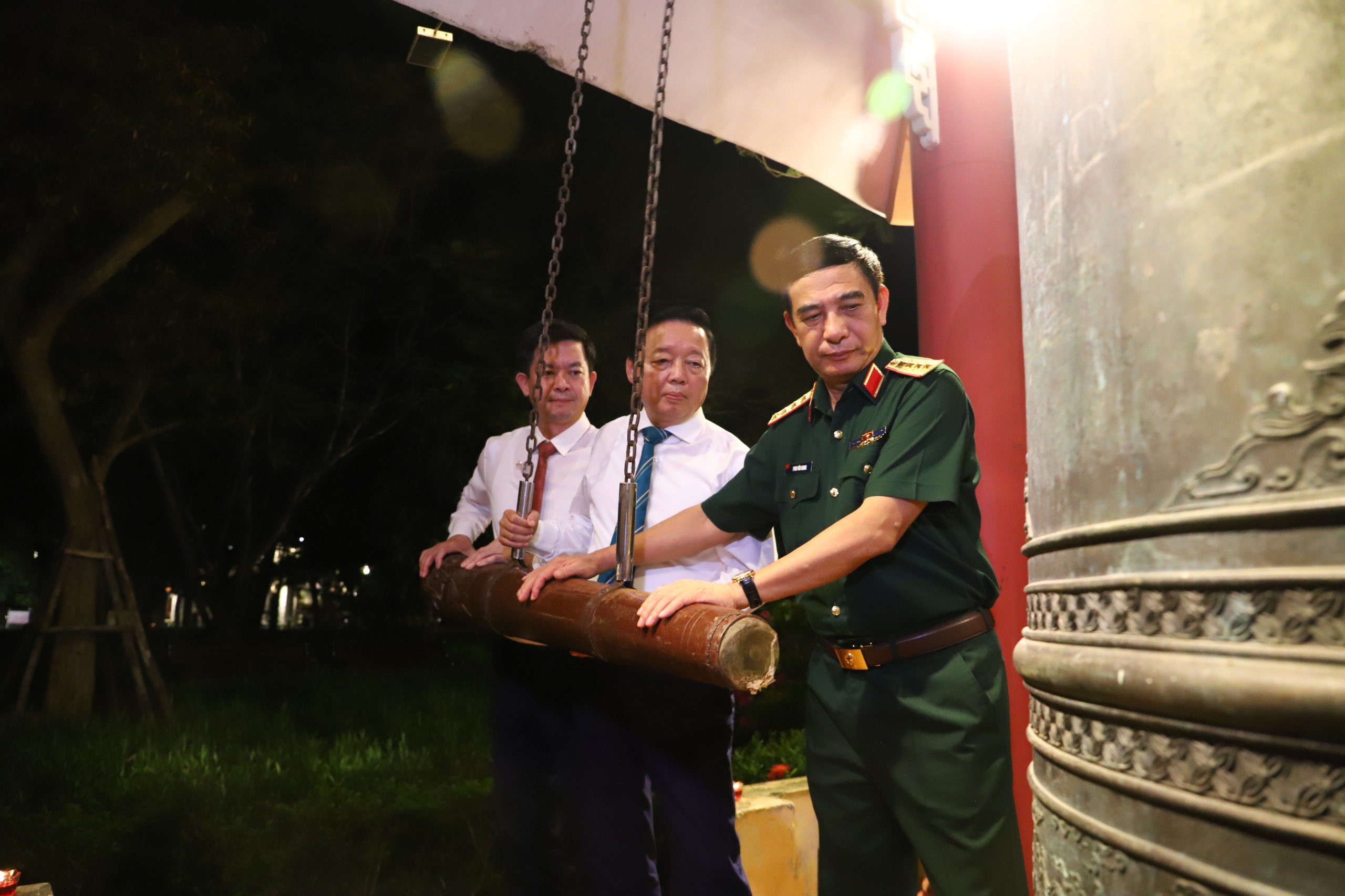 Xúc động, hào hùng với 'Trường Sơn - Chân trần chí thép'- Ảnh 1. Từ phải qua: Đại tướng Phan Văn Giang (Ủy viên Bộ Chính trị, Bộ trưởng Bộ Quốc phòng), ông Trần Hồng Hà (Phó thủ tướng Chính phủ), ông Lê Quang Tùng (Bí thư Tỉnh ủy Quảng Trị) thỉnh chuông tại Nghĩa trang liệt sĩ Trường Sơn trước khi chương trình diễn ra