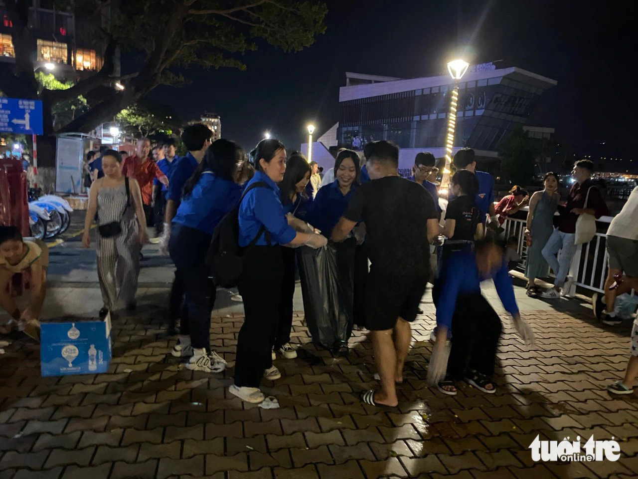 Rác ngổn ngang sau pháo hoa Đà Nẵng, bao giờ hết cảnh người xả người đi dọn?- Ảnh 9. Đoàn viên thanh niên dọn rác trên vỉa hè đường Bạch Đằng - Ảnh: ĐOÀN NHẠN