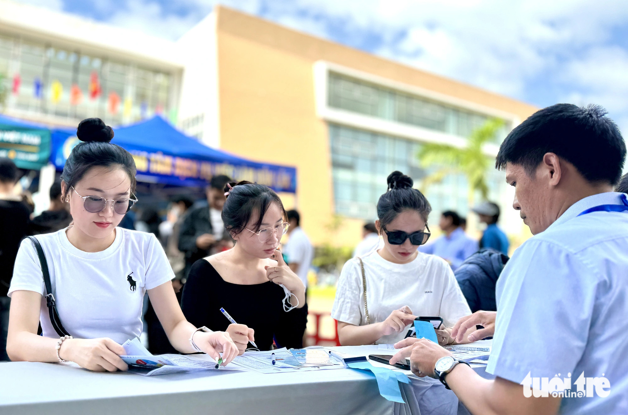 Giúp người lao động hiểu hơn về không dùng tiền mặt- Ảnh 3. Các bạn sinh viên trường nghề đăng ký, tìm hiểu các cơ hội việc làm tại ngày hội - Ảnh: TRUNG TÂN