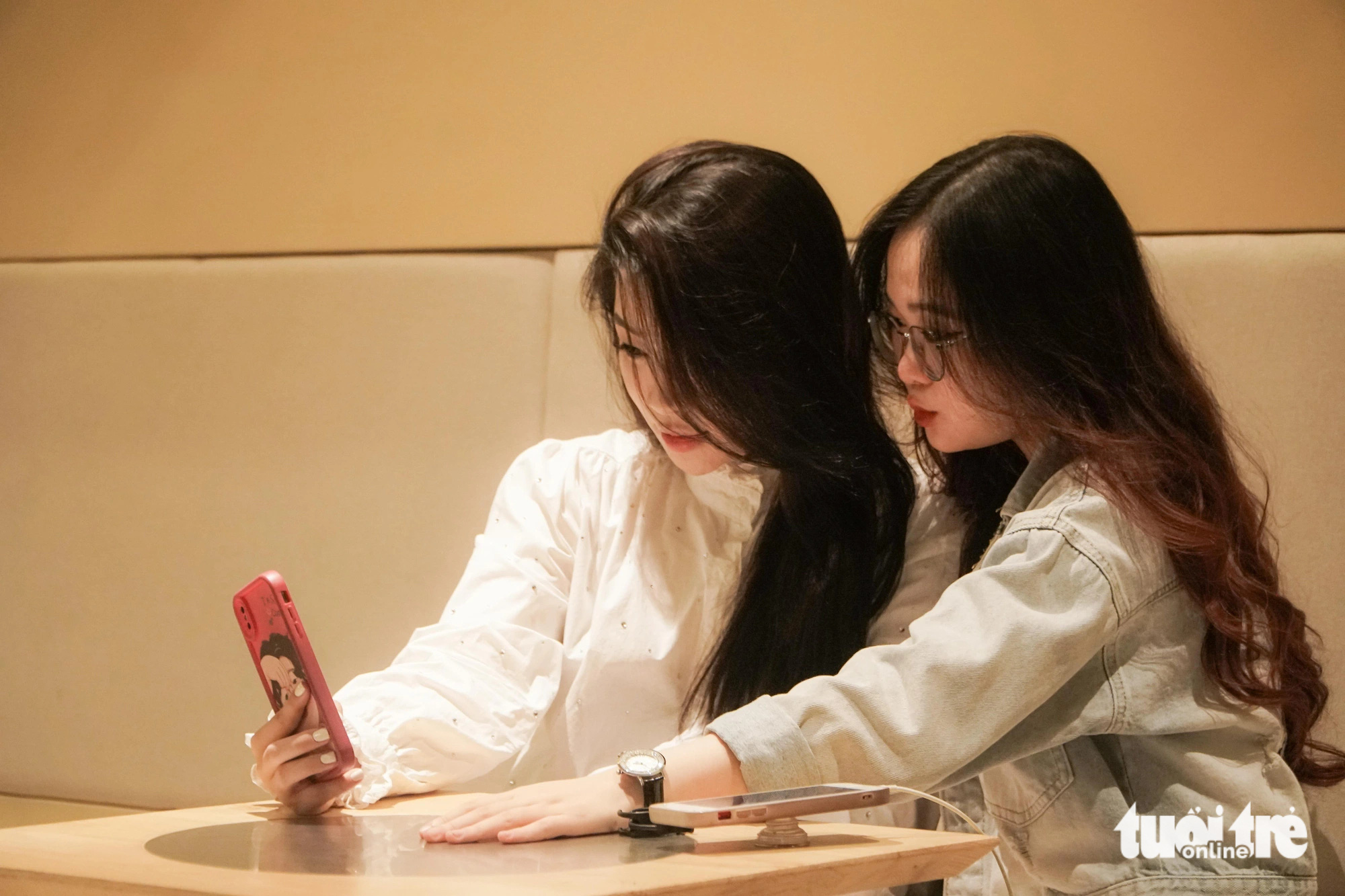 Người trẻ Hà Nội xếp hàng từ 4h sáng để uống cà phê, có người chuẩn bị từ 0h- Ảnh 4. Bạn Trần Thị Nguyệt và bạn Kim Nguyễn Việt Hằng chuẩn bị từ 12h đêm để đi cà phê - Ảnh: PHẠM TUẤN