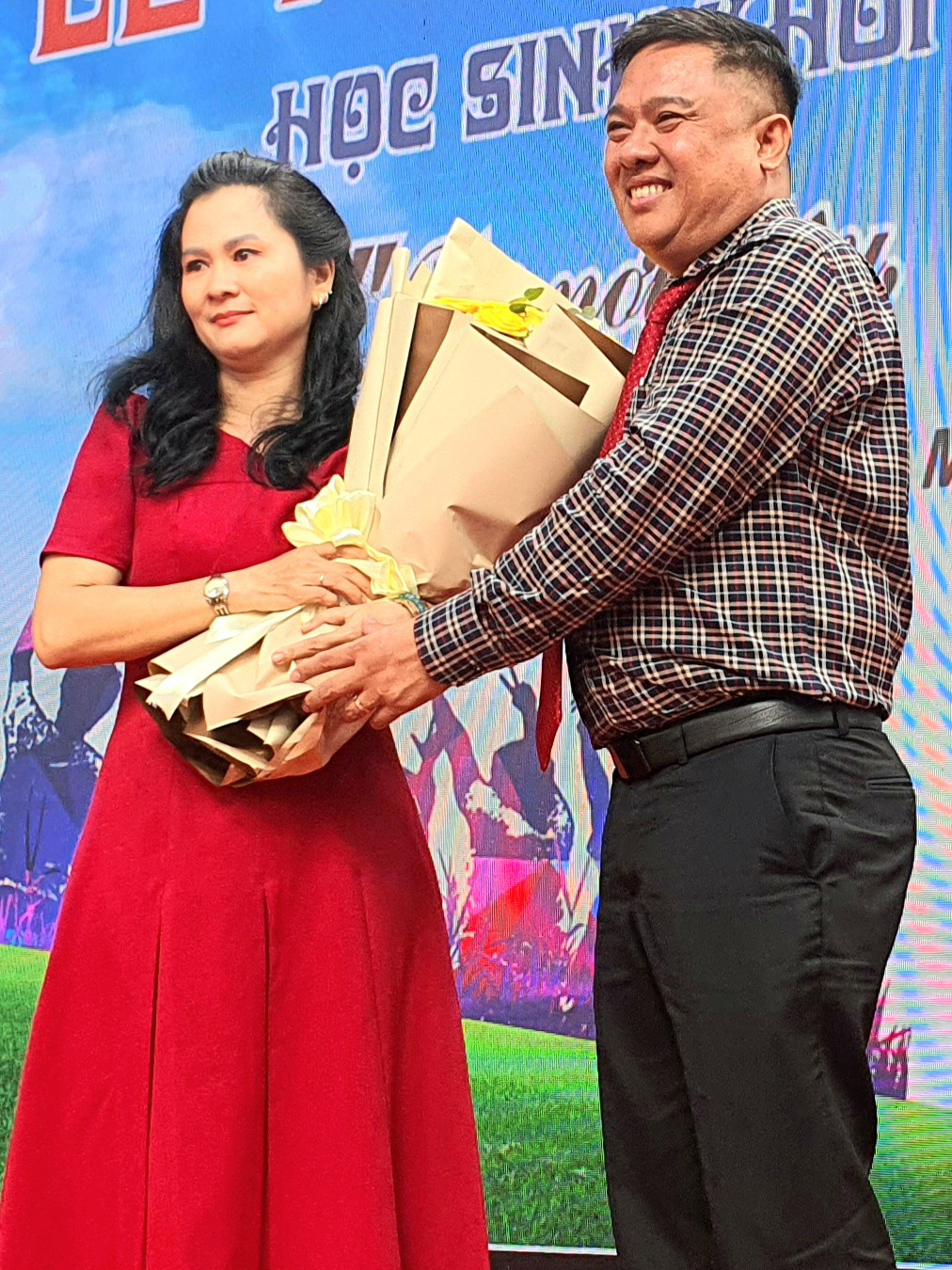 Nước mắt và nụ cười tại lễ trưởng thành của Trường THPT Nguyễn Thị Diệu- Ảnh 5. Ông Dương Văn Thư, hiệu trưởng Trường THPT Nguyễn Thị Diệu tặng hoa tri ân phụ huynh - Ảnh: HOÀNG HƯƠNG