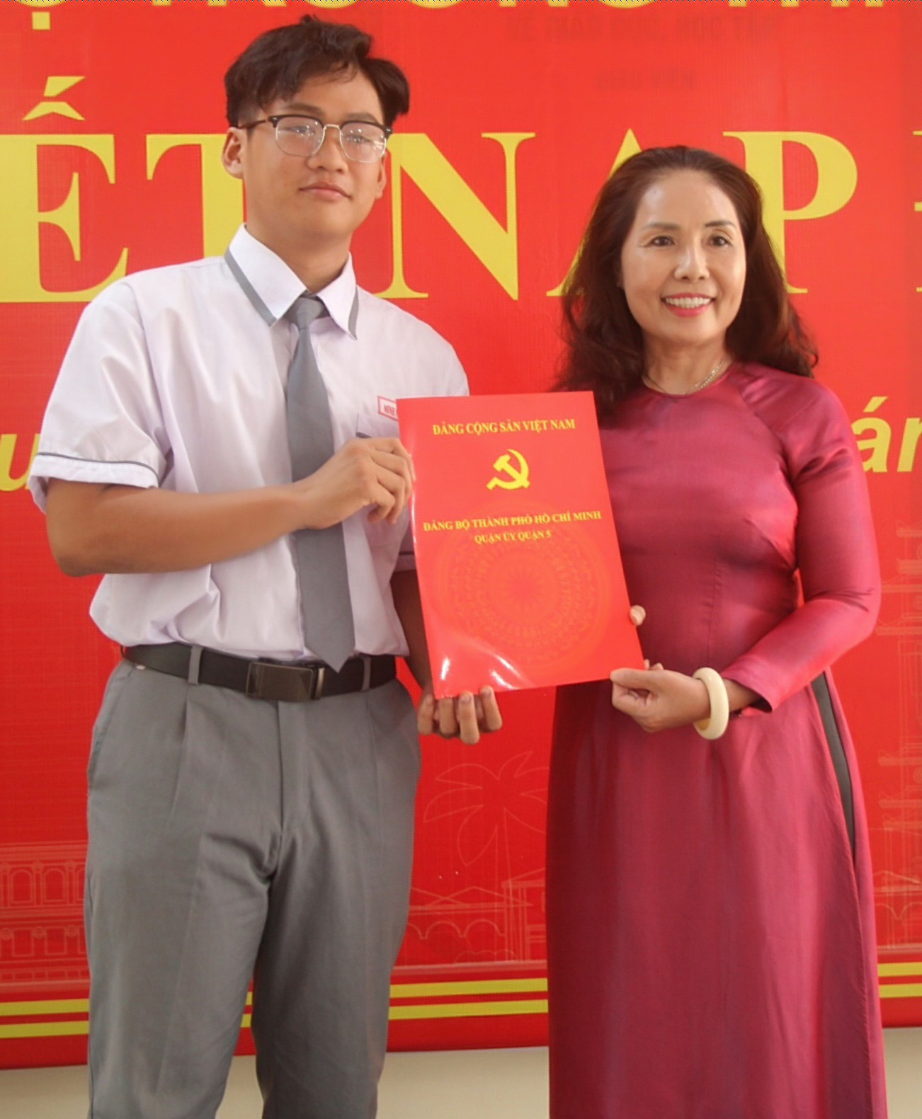 TP.HCM: Học sinh xuất sắc trong học tập, nghiên cứu khoa học được kết nạp Đảng- Ảnh 2. Bà Trương Thị Bích Thủy, hiệu trưởng Trường THPT Hùng Vương, trao quyết định kết nạp Đảng cho Hà Minh Nhật - Ảnh: KIM ANH