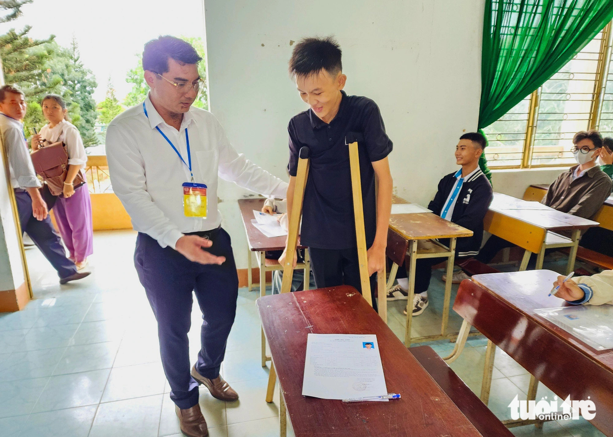 Thí sinh Thân Tiến Thịnh, dự thi tại điểm thi Trường THPT Trần Hưng Đạo (huyện Đắk Mil) được ông Phan Thanh Hải - giám đốc sở GD&ĐT tỉnh Đắk Nông dìu vào bàn thi - Ảnh: TÂM AN Thí sinh Thân Tiến Thịnh, dự thi tại điểm thi Trường THPT Trần Hưng Đạo (huyện Đắk Mil) được ông Phan Thanh Hải - giám đốc sở Giáo dục và Đào tạo tỉnh Đắk Nông dìu vào bàn thi - Ảnh: TÂM AN