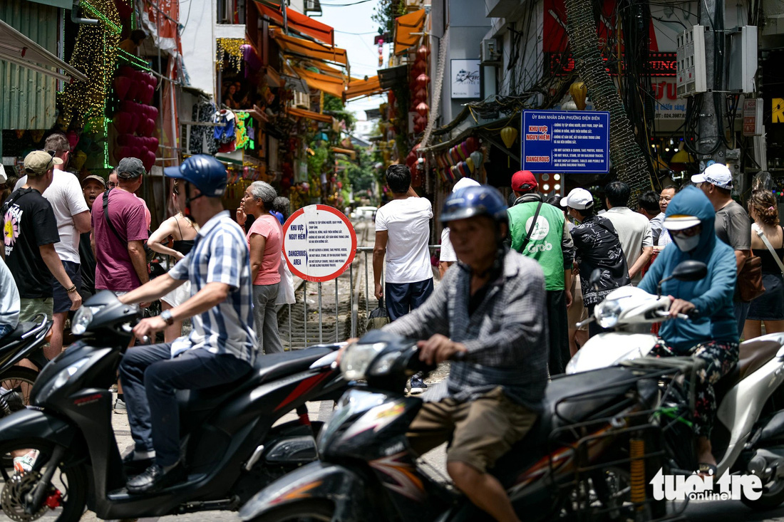 Du khách nước ngoài tập trung đông trước rào chắn vào phố cà phê đường tàu tại Hà Nội - Ảnh: NAM TRẦN Du khách nước ngoài tập trung đông trước rào chắn vào phố cà phê đường tàu tại Hà Nội - Ảnh: NAM TRẦN