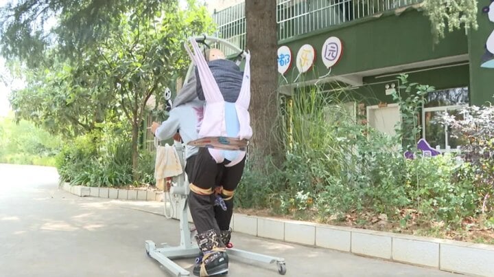 Mẹ già U70 cõng con trai cao 1,82m suốt 5 năm, cố tập cho con đi bộ - Ảnh 1. Mẹ già U70 cõng con trai cao 1,82m suốt 5 năm, cố tập cho con đi bộ - Ảnh 1.