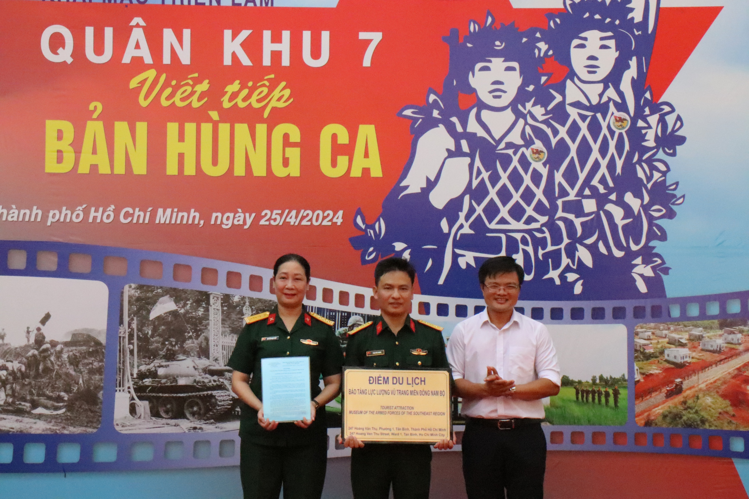 Quân khu 7 triển lãm 'Viết tiếp bản hùng ca'- Ảnh 1. Đại tá Nguyễn Ngọc Điệp (trái), Giám đốc Bảo tàng Lực lượng vũ trang miền Đông Nam bộ nhận quyết định công nhận điểm du lịch của Sở Du lịch TP.HCM