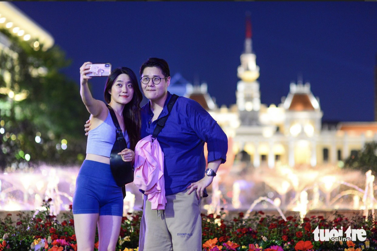 Du khách Hàn Quốc chụp hình lưu niệm trên phố đi bộ Nguyễn Huệ - Ảnh: QUANG ĐỊNH Du khách Hàn Quốc chụp hình lưu niệm trên phố đi bộ Nguyễn Huệ - Ảnh: QUANG ĐỊNH