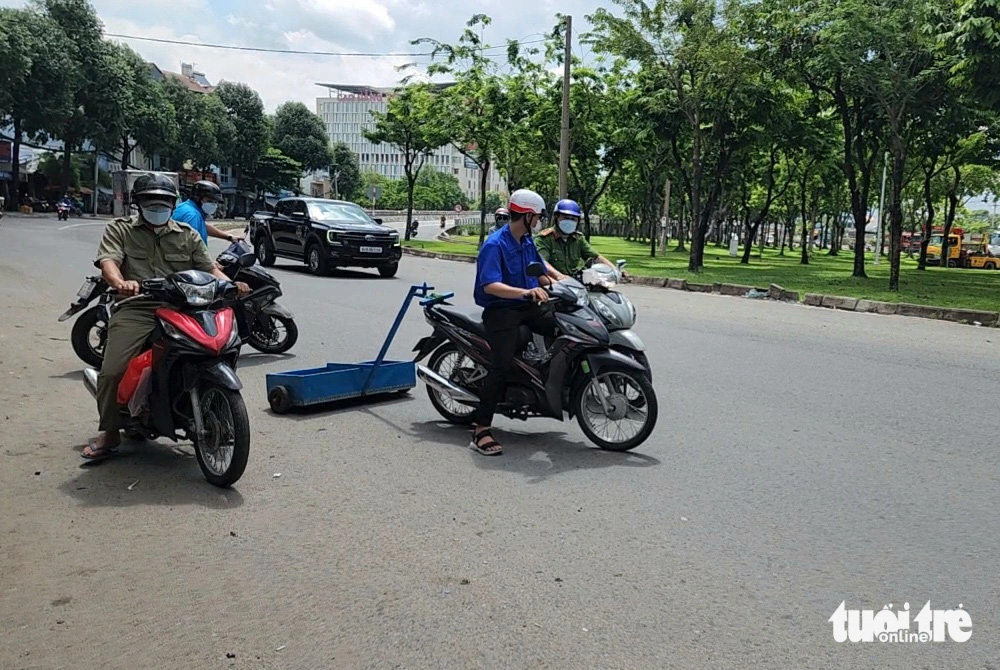 Ra quân hút đinh trên quốc lộ 1, đoạn qua cầu vượt An Sương- Ảnh 1. Đoàn thanh niên phường Trung Mỹ Tây (quận 12) phối hợp với công an phường hút đinh trên quốc lộ 1, đoạn từ cầu vượt Quang Trung đến cầu vượt An Sương - Ảnh: NGỌC KHẢI