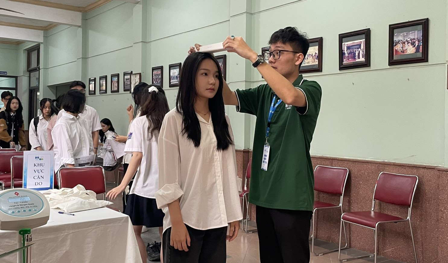 Trường không xét tuyển thí sinh thấp lùn: Bộ GD-ĐT yêu cầu rà soát tiêu chí tuyển sinh- Ảnh 1. Thí sinh đo chiều cao khi tham gia buổi phỏng vấn EQ đầu tiên tại Trường Quản trị và Kinh doanh năm 2024 - Ảnh: HSB