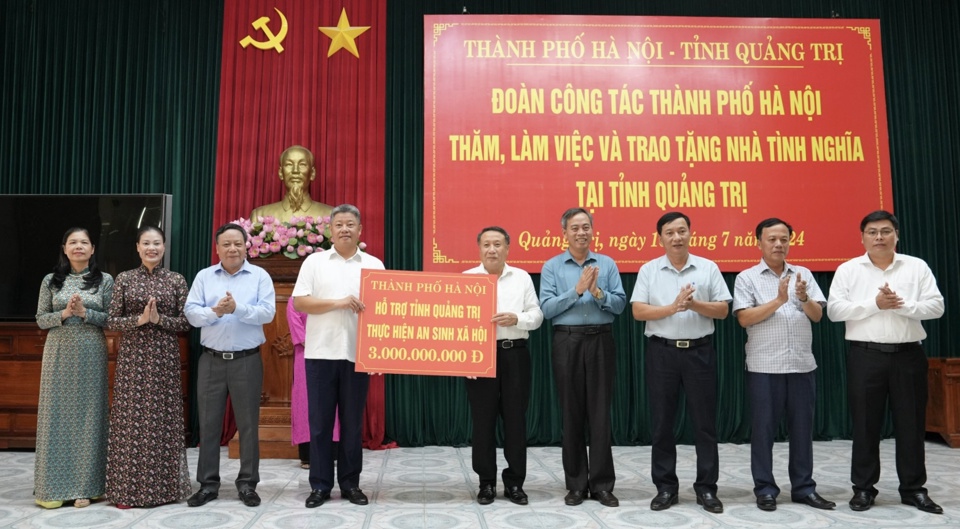 Phó Chủ tịch UBND TP Hà Nội Nguyễn Mạnh Quyền trao biểu trưng hỗ trợ tỉnh Quảng Trị 3 tỷ đồng thực hiện nhiệm vụ an sinh xã hội, xóa đói giảm nghèo. Ảnh Hồng Thái
