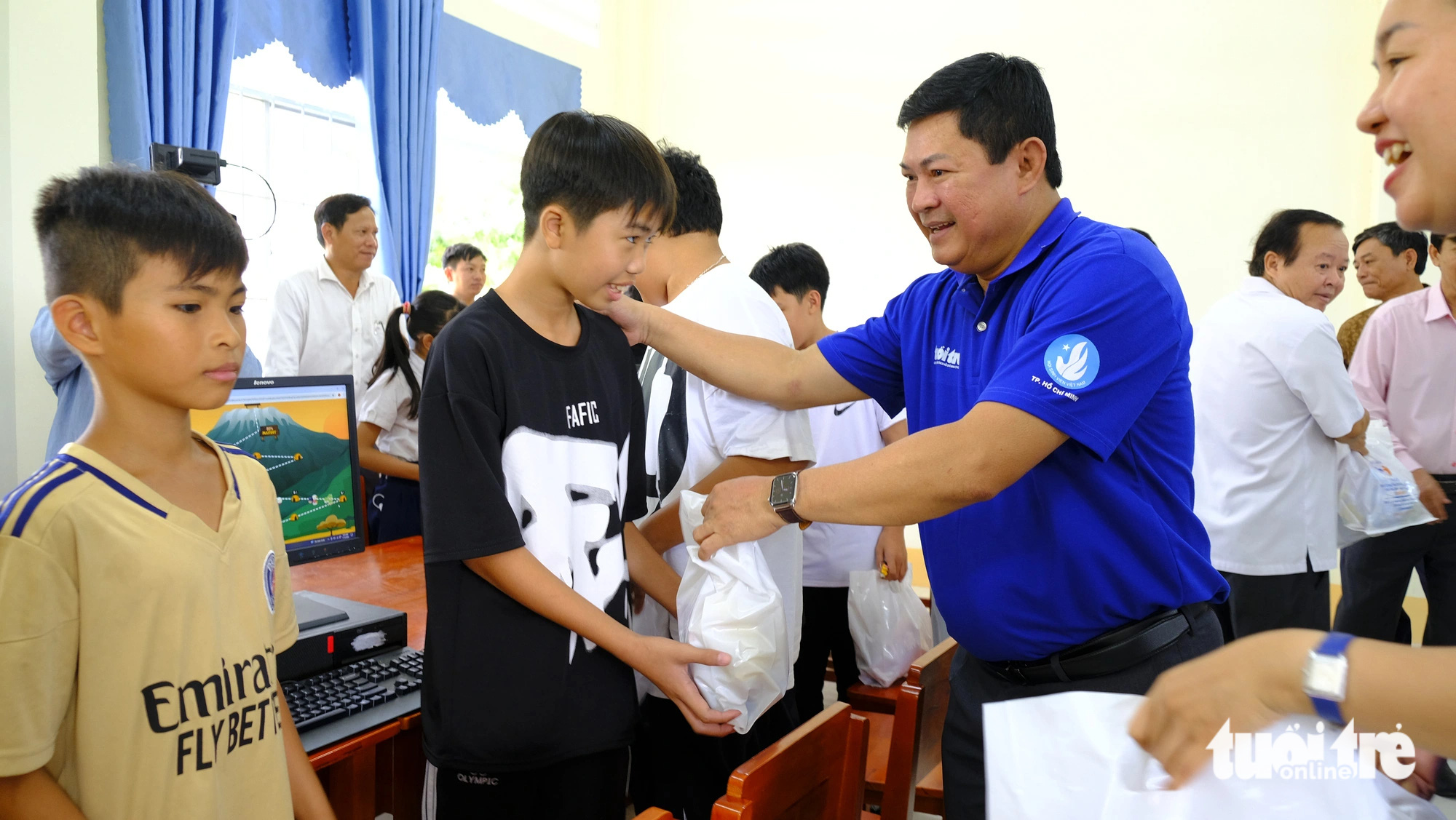 Thành ủy, Thành Đoàn TP.HCM thăm chiến sĩ mùa hè xanh ở Đồng Tháp- Ảnh 4. Ông Huỳnh Cách Mạng - phó trưởng Ban thường trực Ban Tổ chức Thành ủy TP.HCM, trao quà cho học sinh - Ảnh: ĐẶNG TUYẾT
