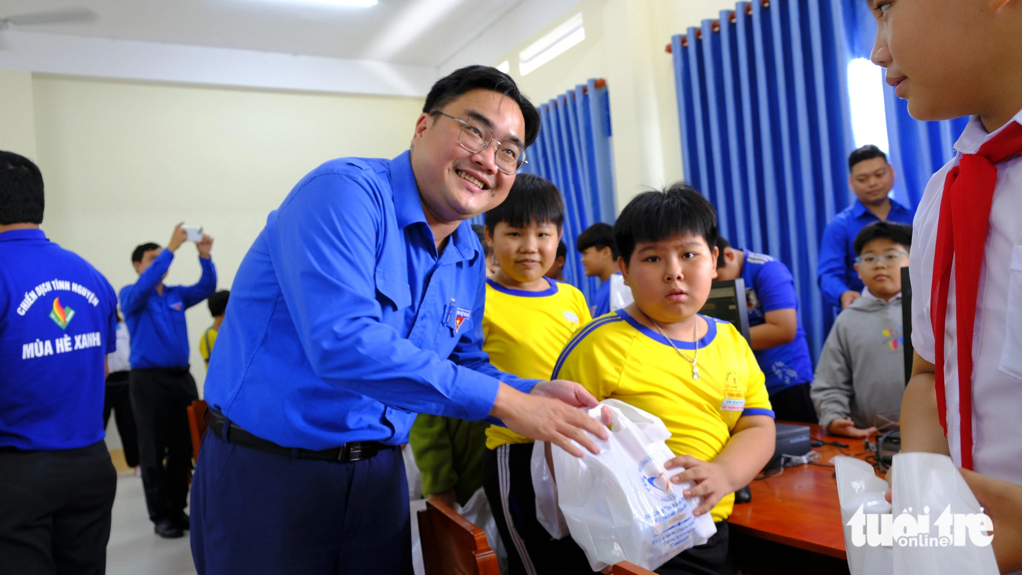 Thành ủy, Thành Đoàn TP.HCM thăm chiến sĩ mùa hè xanh ở Đồng Tháp- Ảnh 5. Anh Ngô Minh Hải trao quà cho học sinh - Ảnh: ĐẶNG TUYẾT