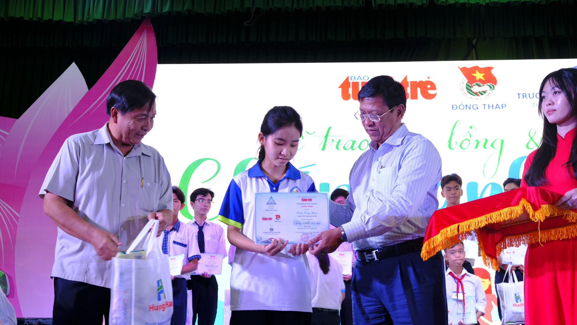 Chắp cánh ước mơ vươn tới tương lai cho học sinh miền Tây- Ảnh 5. Ông Lê Thành Công - trưởng Ban dân vận Tỉnh ủy Đồng Tháp (bìa trái) và ông Trần Thanh Hương - phó chủ tịch thường trực Đại học Văn Hiến trao học bổng cho các em học sinh khu vực miền Tây - Ảnh: ĐẶNG TUYẾT