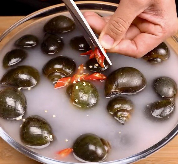 Người ta ngâm ốc vào nước vo gạo, kèm ớt để khử mùi tanh - Ảnh: Dat Vai Ngang Food Người ta ngâm ốc vào nước vo gạo kèm ớt để khử mùi tanh - Ảnh: Dat Vai Ngang Food