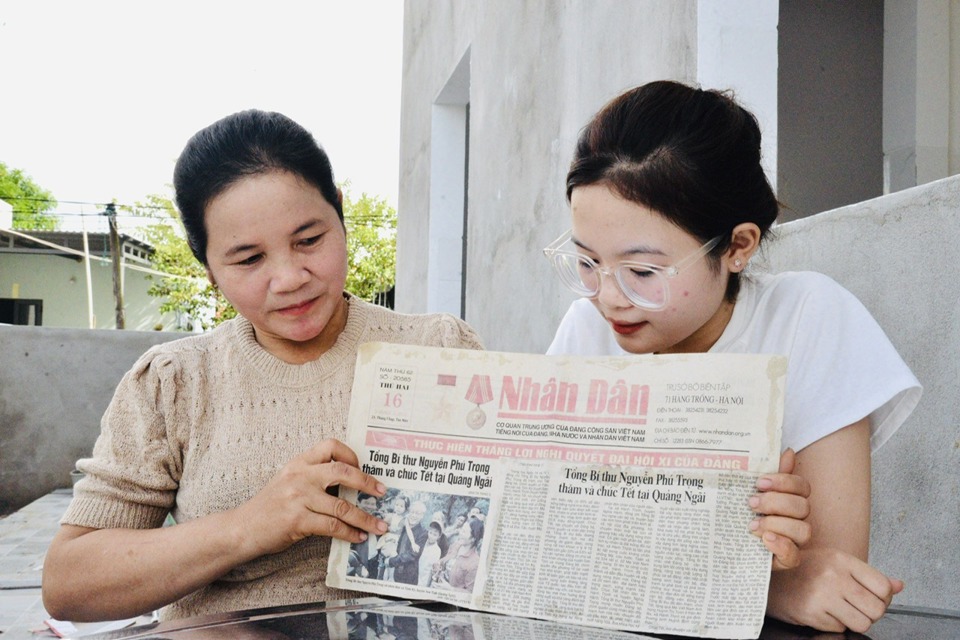 Chị Trần Thị Chung và con gái Phạm Thị Thu Hiền bên tờ báo có tấm ảnh ghi lại khoảnh khắc đáng nhớ. Ảnh NVCC
