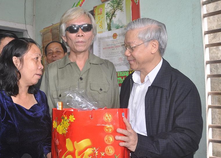 Tổng Bí thư Nguyễn Phú Trọng thăm, tặng quà thương binh Huỳnh Bình năm 2012. Ảnh NVCC