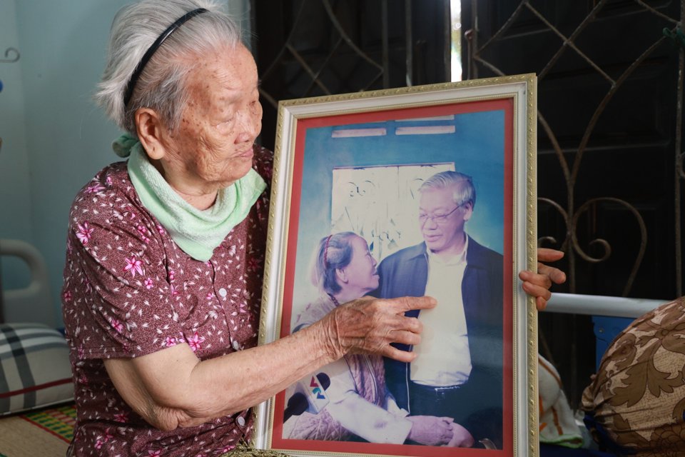 Mẹ Việt Nam Anh hùng Huỳnh Thị Toàn bên bức ảnh chụp chung với Tổng Bí thư Nguyễn Phú Trọng năm 2012. Ảnh NVCC