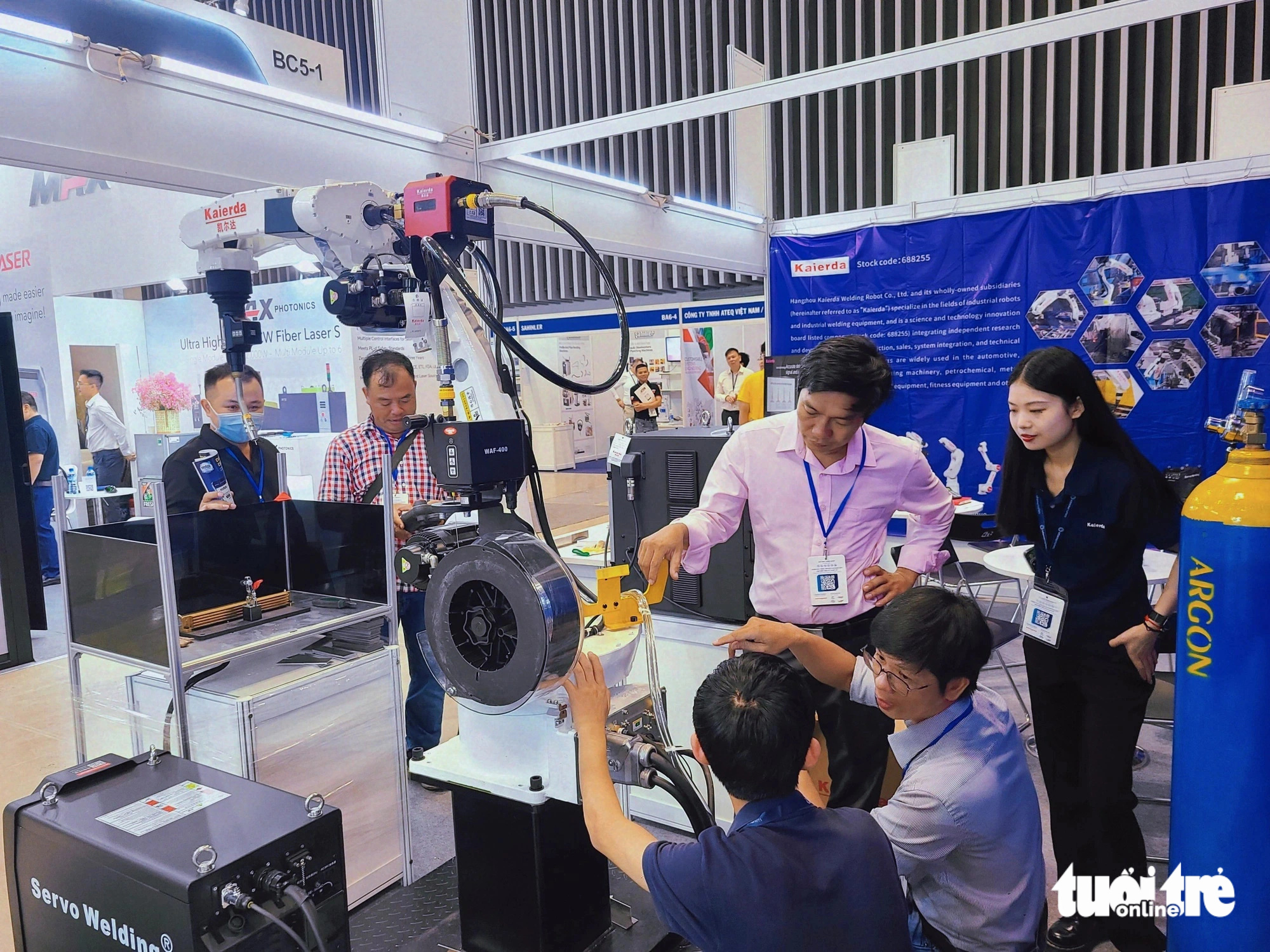 Khám phá công nghệ mới nhất ngành cơ khí tại MTA Vietnam 2024- Ảnh 1. Khách tham quan tìm hiểu một chiếc tay robot tại MTA Vietnam 2024 - Ảnh: NHẬT XUÂN