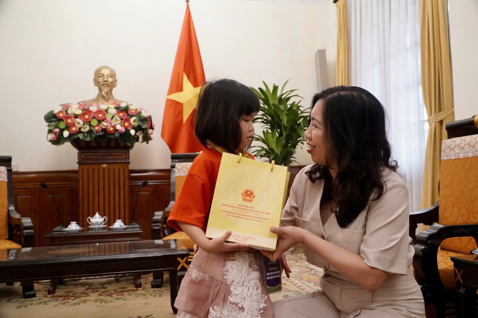 Thứ trưởng tặng những cuốn truyện tranh về lịch sử dân tộc cho các em thiếu nhi thành viên của Đoàn. Ảnh: Bộ Ngoại giao