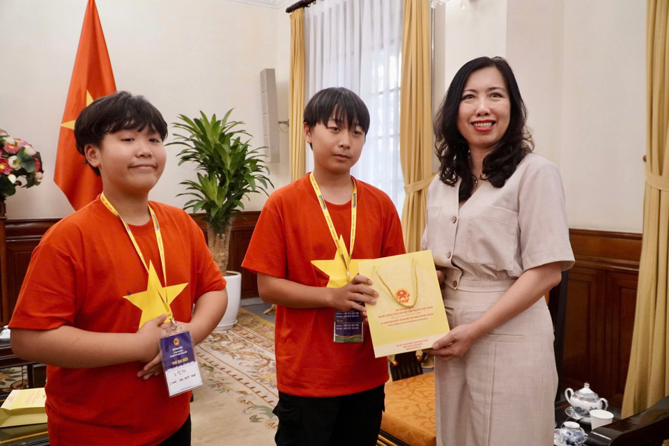 Thứ trưởng tặng những cuốn truyện tranh về lịch sử dân tộc cho các em thiếu nhi thành viên của Đoàn. Ảnh: Bộ Ngoại giao