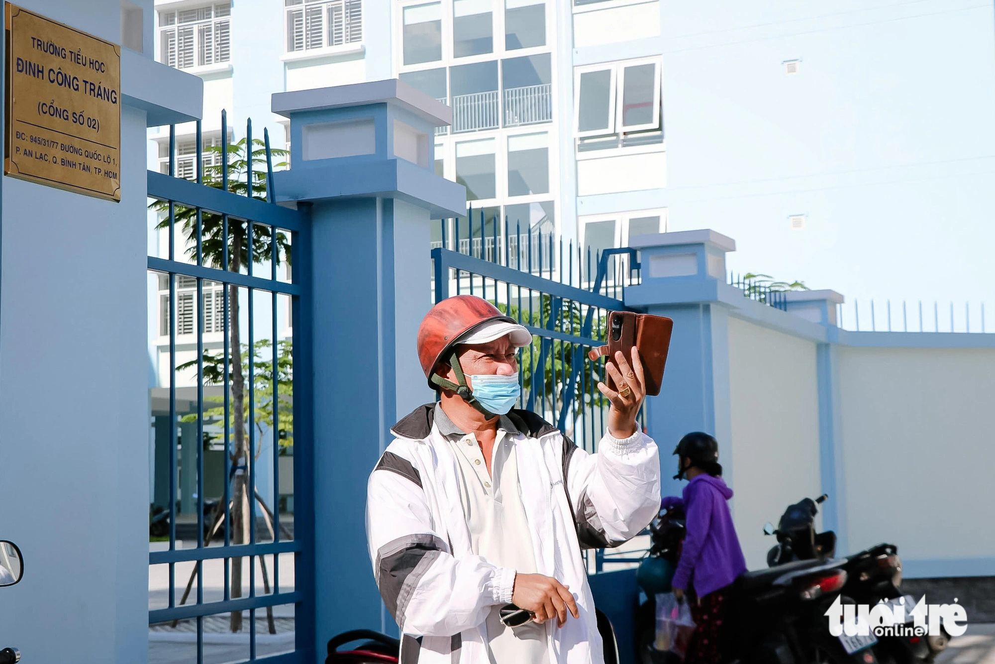 7 ngôi trường mới khang trang ở Bình Tân sẵn sàng đón học sinh- Ảnh 10. Nhiều phụ huynh háo hức chở con đến xem trường mới và chụp ảnh trước cổng Trường tiểu học Đinh Công Tráng chiều 5-8 - Ảnh: CẨM NƯƠNG
