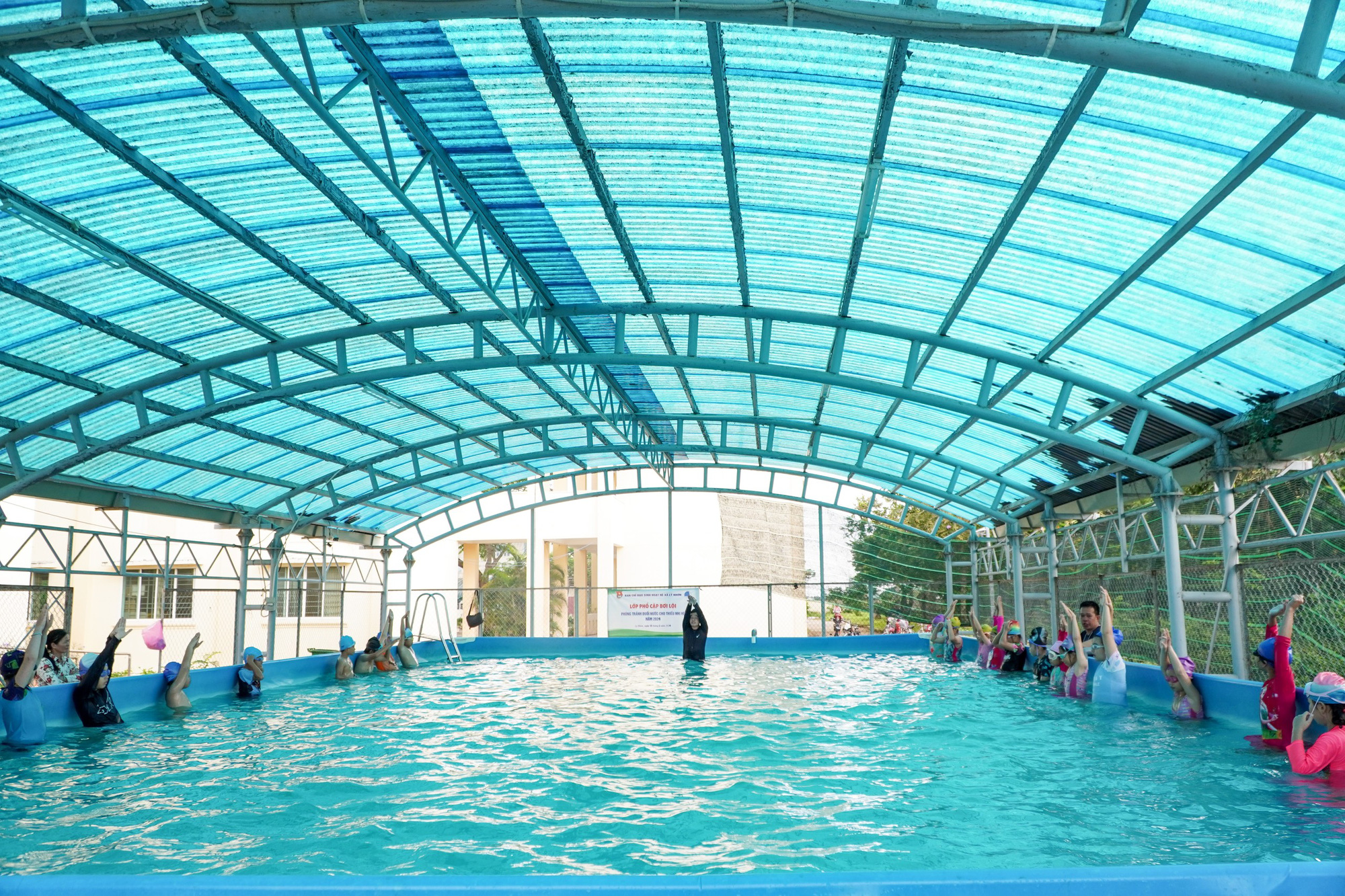Các học sinh được chia tập theo từng nhóm, người bơi giỏi sẽ chỉ ngược lại những bạn còn yếu - Ảnh: AN VI Lớp dạy bơi miễn phí cho trẻ ở huyện đảo TP.HCM- Ảnh 3.