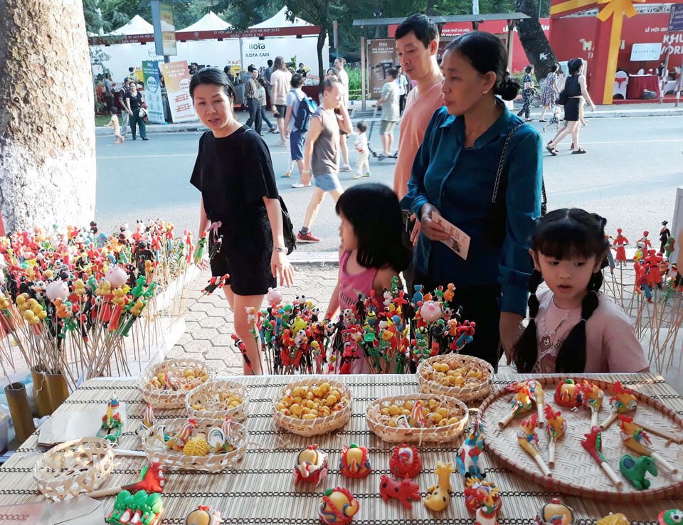 Các em nhỏ tiếp cận sản phẩm tò he của làng nghề Xuân La (xã Phượng Dực-huyện Phú Xuyên). Ảnh: Hoài Nam
