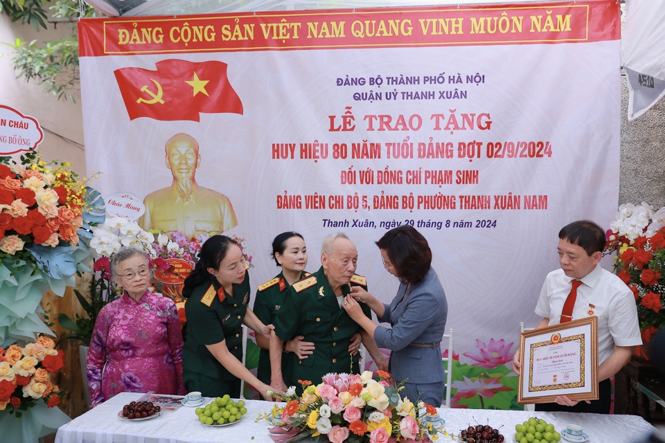 Ủy viên Ban Thường vụ Thành ủy, Bí thư Quận ủy Thanh Xuân Bùi Huyền Mai gắn Huy hiệu 80 năm tuổi Đảng tặng đảng viên lão thành Phạm Sinh