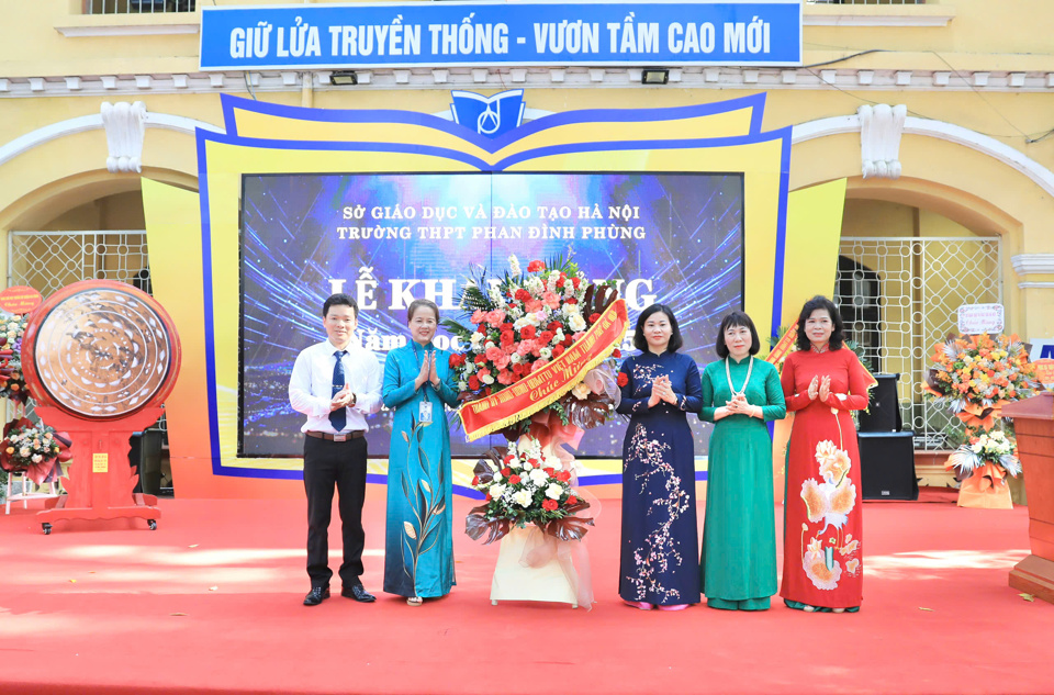 Thay mặt lãnh đạo TP Hà Nội, Phó Bí thư Thường trực Thành ủy Nguyễn Thị Tuyến tặng hoa chúc mừng các thầy cô giáo và học sinh Trường THPT Phan Đình Phùng.