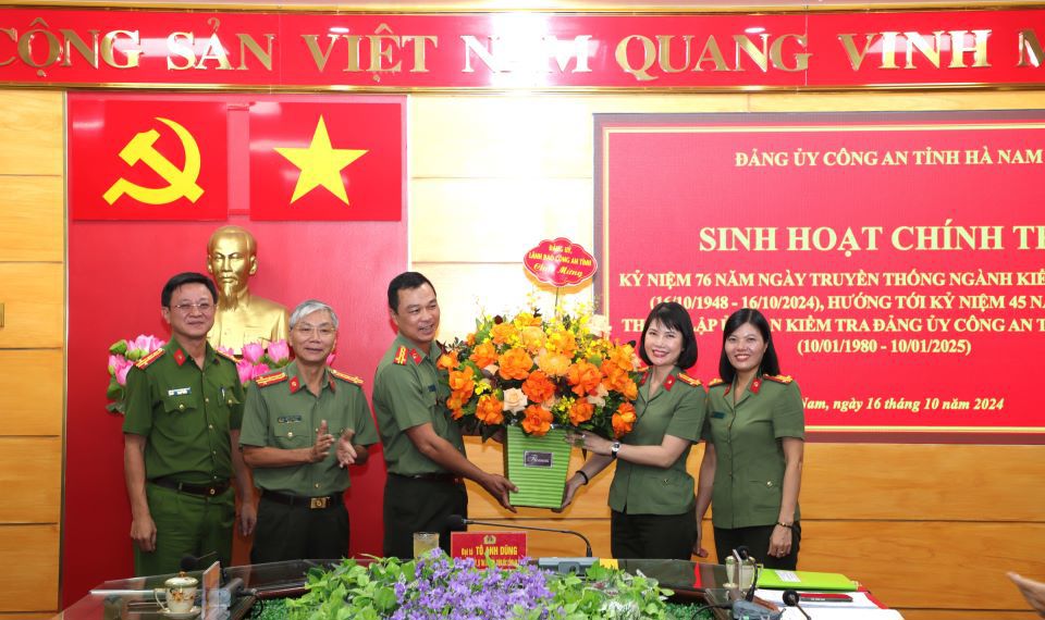 Các đồng chí lãnh đạo Công an tỉnh tặng hoa chúc mừng Cơ quan Ủy ban Kiểm tra Đảng ủy Công an tỉnh. Ảnh: Ánh Tuyết